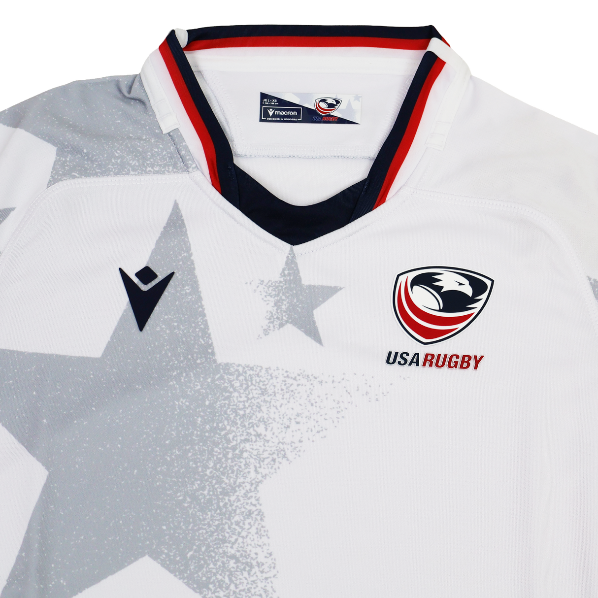 The Youth USA Rugby 24/25 Away Jersey by Macron features a white base with a bold gray star pattern, USA Rugby and Macron logos on the chest, and red, white, and blue collar trim.