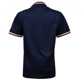 The Women's USA Rugby 25/26 Replica Home Jersey by Macron is a short-sleeved navy top, shown from the back, with red, white, and blue sleeve cuff stripes—designed in the style of official USA Rugby replica apparel.