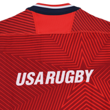 The USA Rugby 24/25 Red Replica Training Jersey by Macron features bold white "USA RUGBY" text and a striking star pattern on the back.