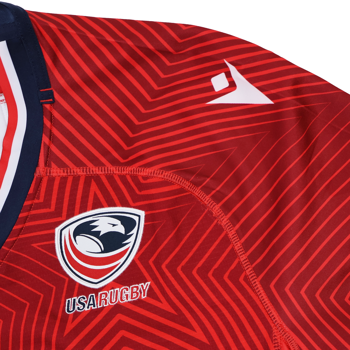 Close-up of the USA Rugby 24/25 Red Replica Training Jersey by Macron, showcasing a geometric pattern, the eagle logo, and a white Macron logo on the shoulder.