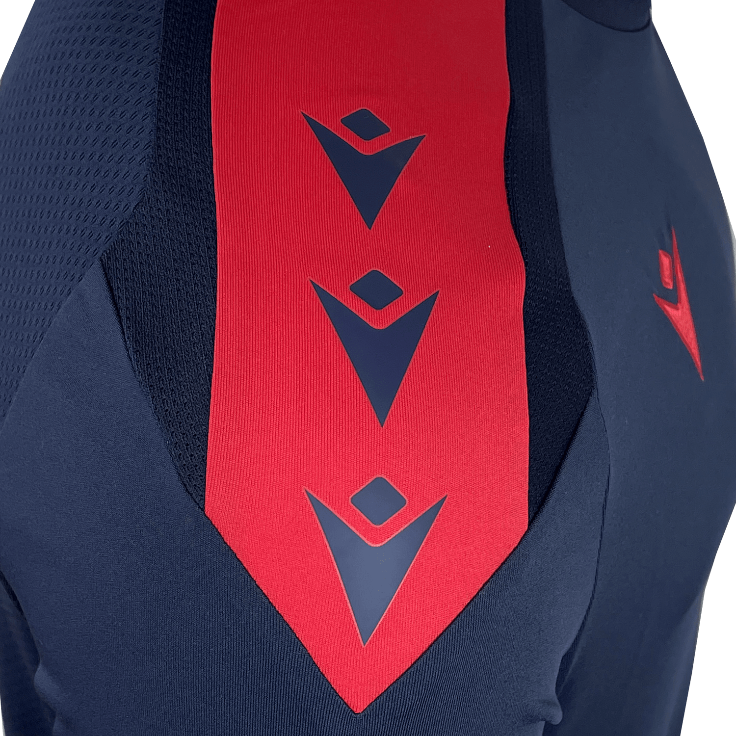 Close-up of the USA Rugby 25 Player Long Sleeve Training Shirt by Macron in navy blue, featuring a red vertical stripe with three geometric navy logos and a chest logo.