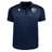 The USA Rugby 25 Travel Poly Polo by Macron is a navy blue, short-sleeve polo featuring the USA Rugby logo on the left chest and a white Macron logo on the right chest.