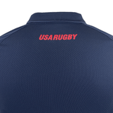 Back view of the USA Rugby 25 Travel Poly Polo by Macron in navy blue, featuring "USA RUGBY" boldly printed in red uppercase letters near the collar.
