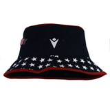 The USA Rugby 25 Bucket Hat by Macron, in black, showcases a triangle logo on the front, white stars on the brim, and a striking red trim—ideal for any USA Rugby fan.