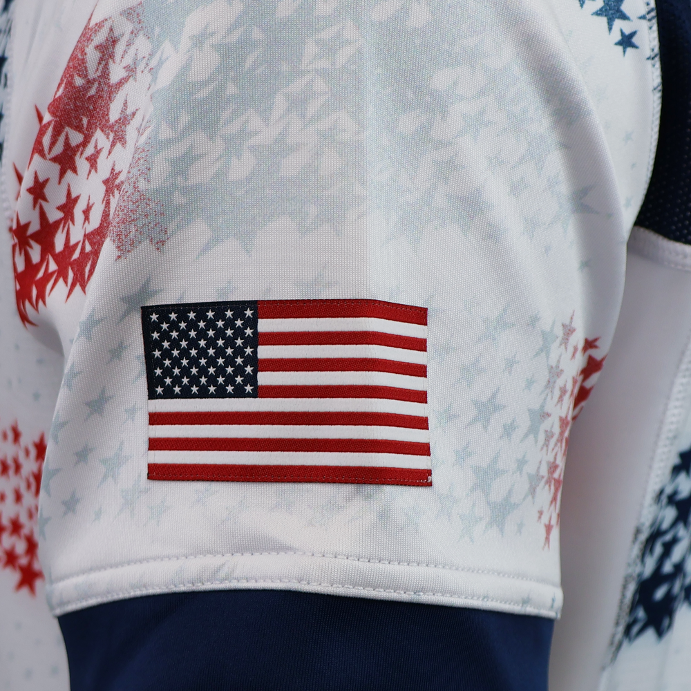 A close-up of the American flag patch on the sleeve highlights the sleek design of the USA Rugby 25/26 Home Body Fit Match Jersey by Macron, featuring a star pattern on this performance-driven rugby shirt.