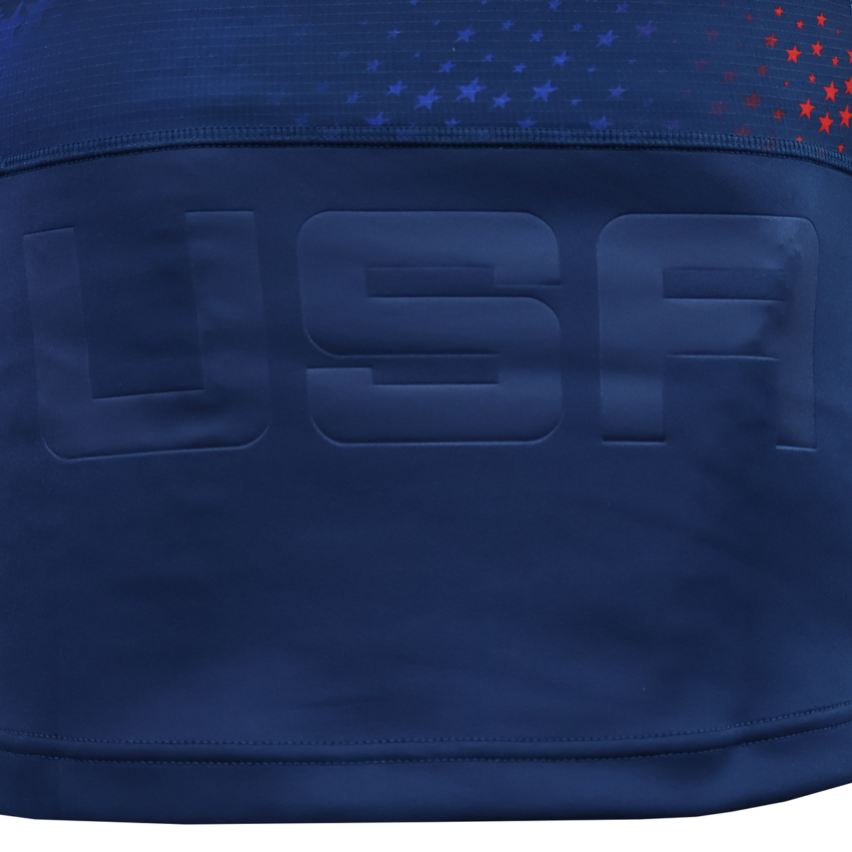 The USA Rugby 25/26 Away Body Fit Match Jersey by Macron features navy blue fabric with "USA" in large letters and a top section decorated with small red and blue stars, reflecting the authentic style of a Macron rugby jersey.