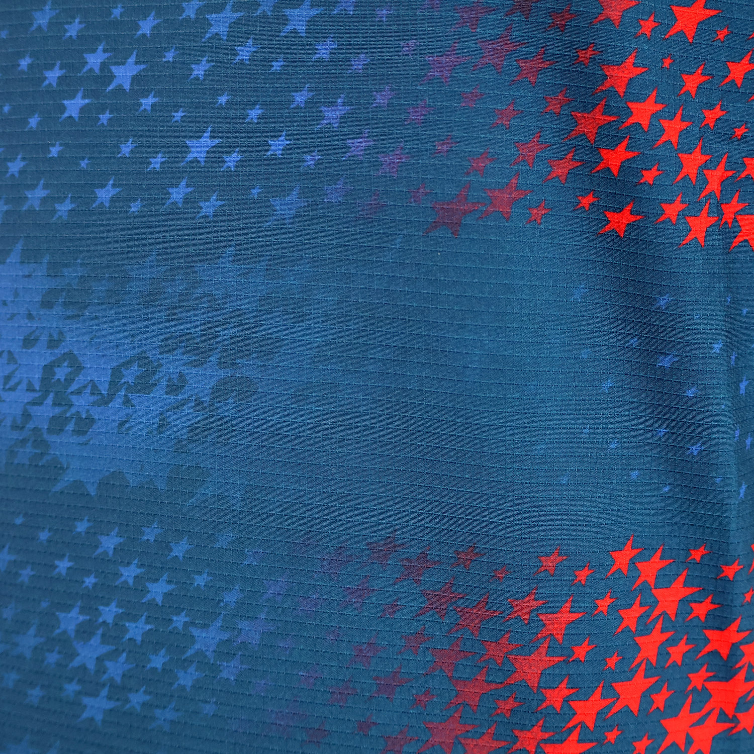 The USA Rugby 25/26 Away Body Fit Match Jersey by Macron features blue fabric with red and blue stars fading from right to left—ideal for high-performance, inspired by classic USA Rugby designs.