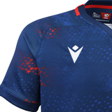 Close-up of the USA Rugby 25/26 Away Body Fit Match Jersey by Macron, featuring red and blue star patterns, a white Macron logo, and red collar trim.