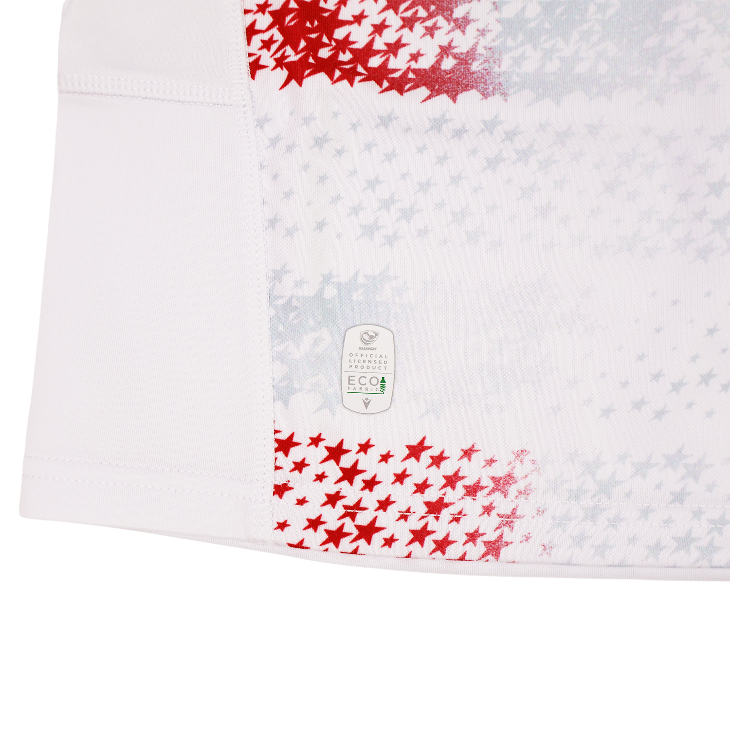 The Youth USA Rugby 25/26 Home Replica Jersey by Macron features white fabric with red and gray stars, visible stitching, and an "Eco" label near the hem, combining sporty style with everyday comfort.