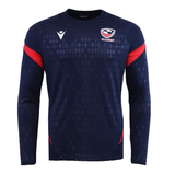 The USA Rugby 25/26 LS Training Poly Shirt by Macron features a navy design with diamond pattern, red sleeve accents, and the USA Rugby logo—an ideal long sleeve training shirt for both practice and casual wear.