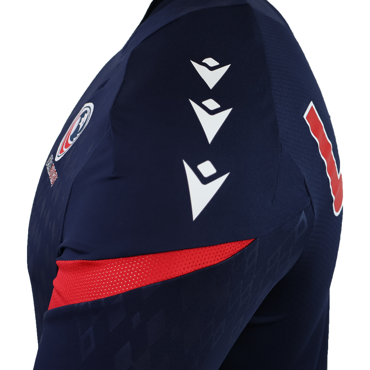 Close-up of the USA Rugby 25/26 LS Training Poly Shirt by Macron: a navy long sleeve jersey with three white shoulder chevrons, chest logo, red accents, and a bold red and white "L" on the sleeve.