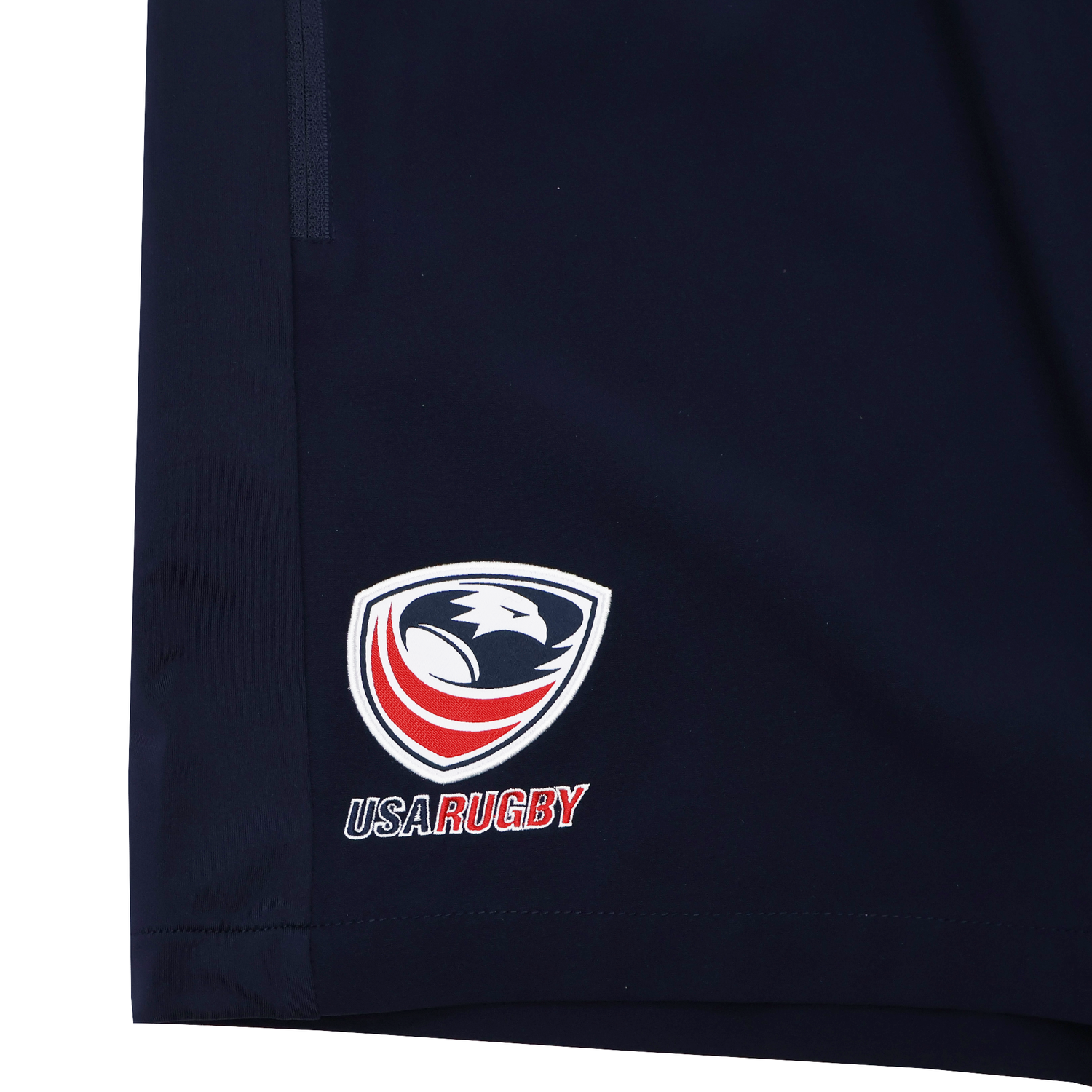 The USA Rugby 25/26 Training Micro Bermuda by Macron features navy blue fabric with the USA Rugby logo and text embroidered on the lower corner.