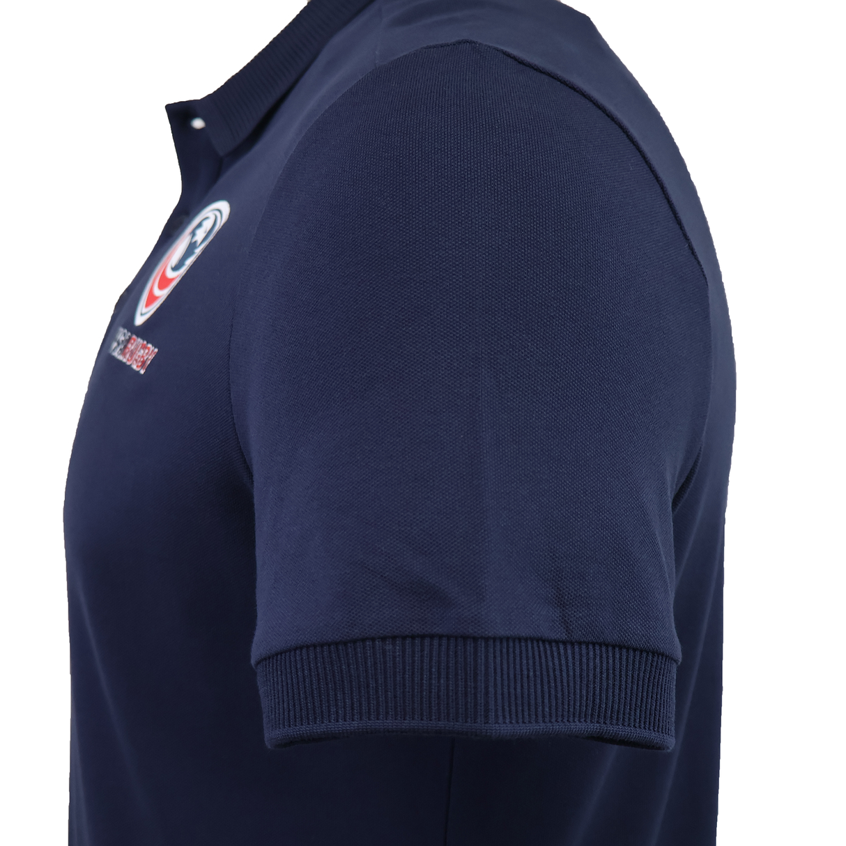 Side view of the USA Rugby 25/26 Athleisure Cotton Polo by Macron in dark blue, featuring a ribbed collar, sleeve cuffs, and a small embroidered chest logo for an easy athleisure style.