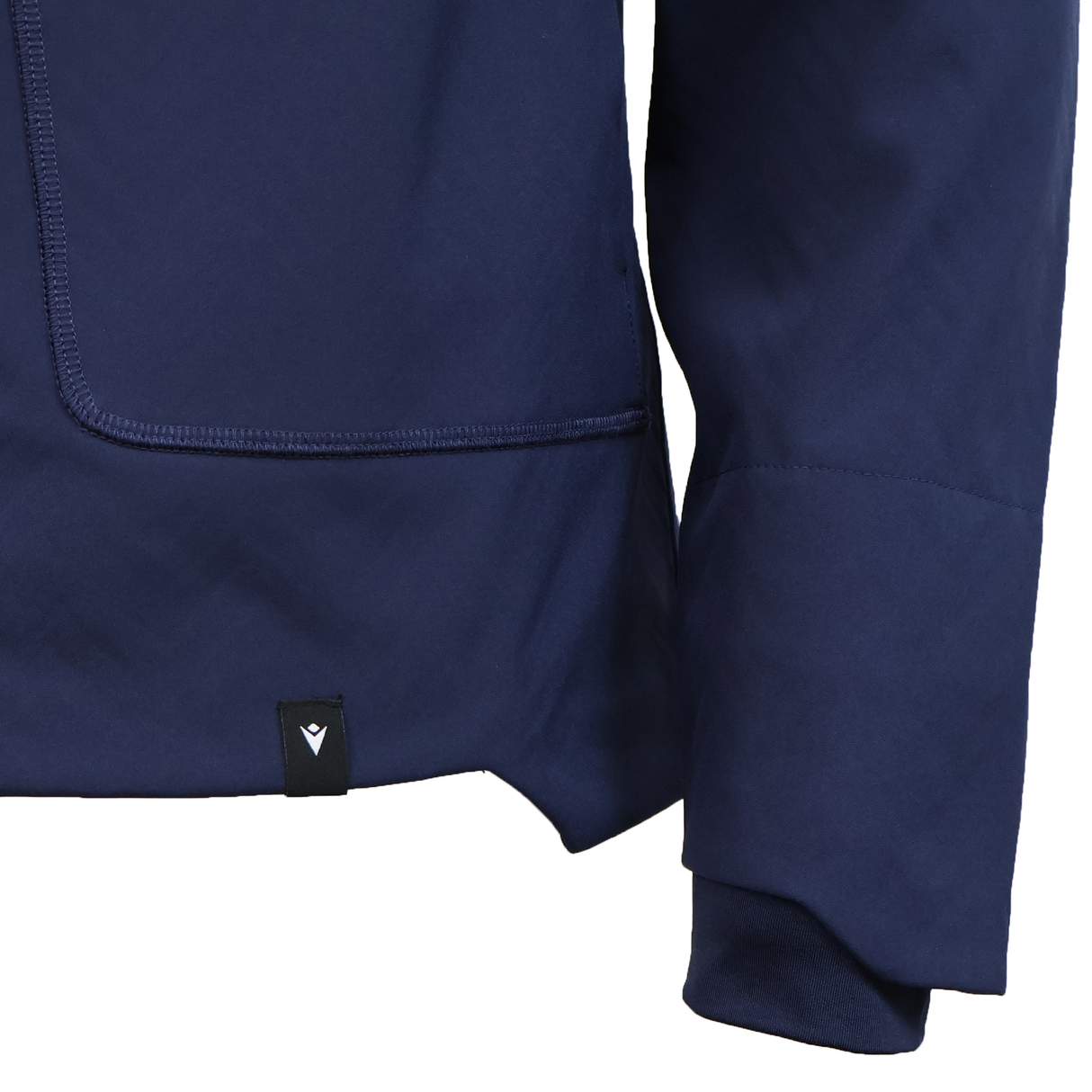 Close-up of the USA Rugby 25/26 Athleisure Softshell Jacket by Macron in navy blue, showcasing its pocket, sleeve, and a small black tag with a white emblem. This Macron jacket combines water resistance with athleisure style.