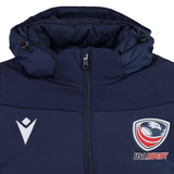 The USA Rugby 25/26 Padded Jacket by Macron is a navy blue jacket with a front zipper, featuring the USA Rugby logo on the right chest and a white Macron logo on the left chest.
