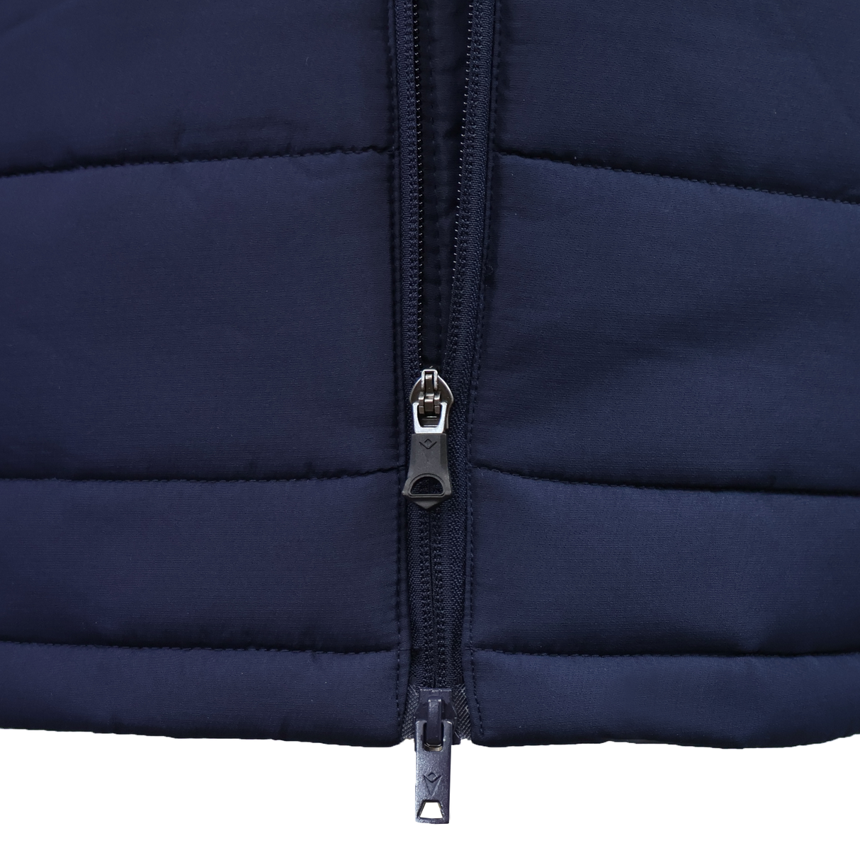 Close-up of the USA Rugby 25/26 Padded Jacket by Macron in navy blue, featuring horizontal stitching and a double zipper, partially unzipped.