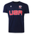 The USA Rugby M25/26 Leisure Shirt by Macron features "USA" in bold red letters, a white USA Rugby logo, the USAR M25/26 insignia, and a white Macron logo on the front.