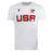 The USA Rugby M25/26 Leisure Shirt by Macron is a white short-sleeve shirt with "USA" in bold red, the USA Rugby logo on the right, and a black Macron logo on the left.