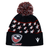 The USA Rugby 25/26 Pompom Beanie by Macron is a black acrylic knit hat featuring white stars, red accents, a top pom-pom, and embroidered USA Rugby and Macron logos on the front cuff.
