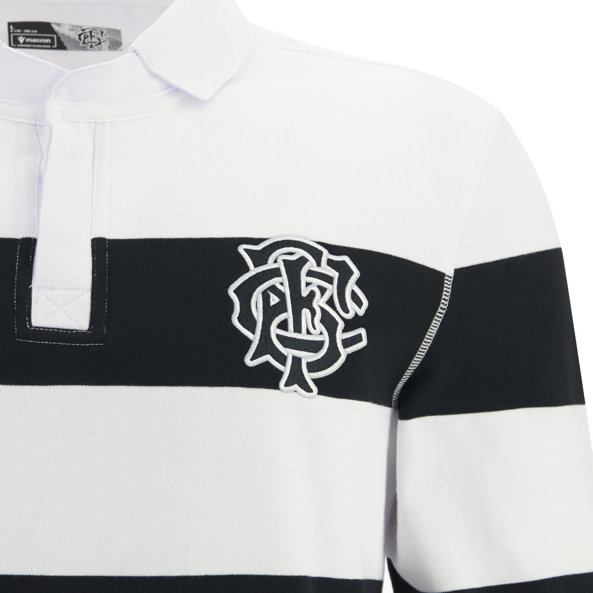 A close-up of the Barbarians 25/26 Cotton Long Sleeve Home Jersey by Macron, featuring black and white stripes, a collared neckline, and an embroidered monogram logo on the left chest.