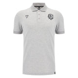 The Barbarians 25/26 Player Travel Polo by Macron is a light grey short-sleeve polo with a three-button placket, black embroidered chest logos, and a classic collar.