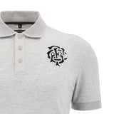 The Barbarians 25/26 Player Travel Polo by Macron is a gray short-sleeve rugby polo with a collar, three buttons, and a black embroidered monogram logo on the left chest.