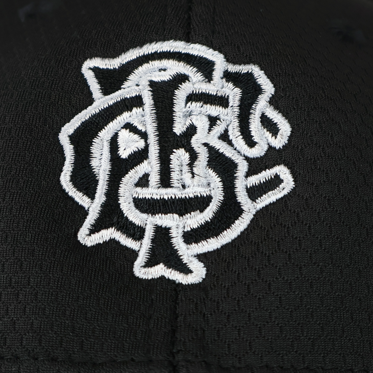 Close-up of the Barbarians 25/26 Baseball Cap by Macron in black, featuring a white embroidered monogram logo, celebrating the 25/26 season.