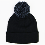 The Barbarians 25/26 Pom-Pom Beanie by Macron features a wide folded brim and a large, fluffy pom-pom on top, shown here in black against a white background.