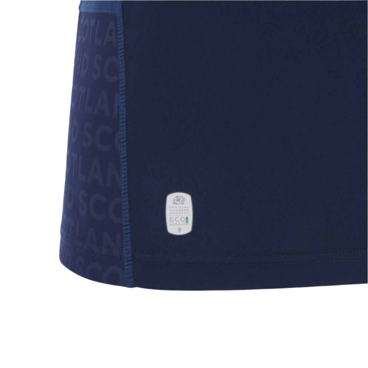 Close-up of the Scotland SRU 25/26 Replica Home Jersey by Macron in navy blue, showing the "SCOTLAND" text pattern, visible stitching, and an ECO label on the fabric.