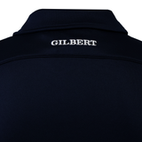 Close-up of the back of a dark-colored Gilbert Photon II Polo, made from lightweight fabric, featuring "GILBERT" embroidered in white on the upper back.