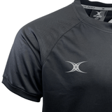 Close-up of a black Gilbert Evo Performance Training Tee with a subtle zigzag pattern on the shoulder. This rugby training shirt features a small, silver Gilbert logo on the left chest area with two curved lines crossing.