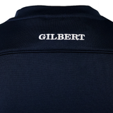 Close-up of the upper back of the Gilbert Photon Training Tee in dark navy, featuring "GILBERT" embroidered in white capitals. This moisture-wicking tee by Gilbert offers added comfort during training.