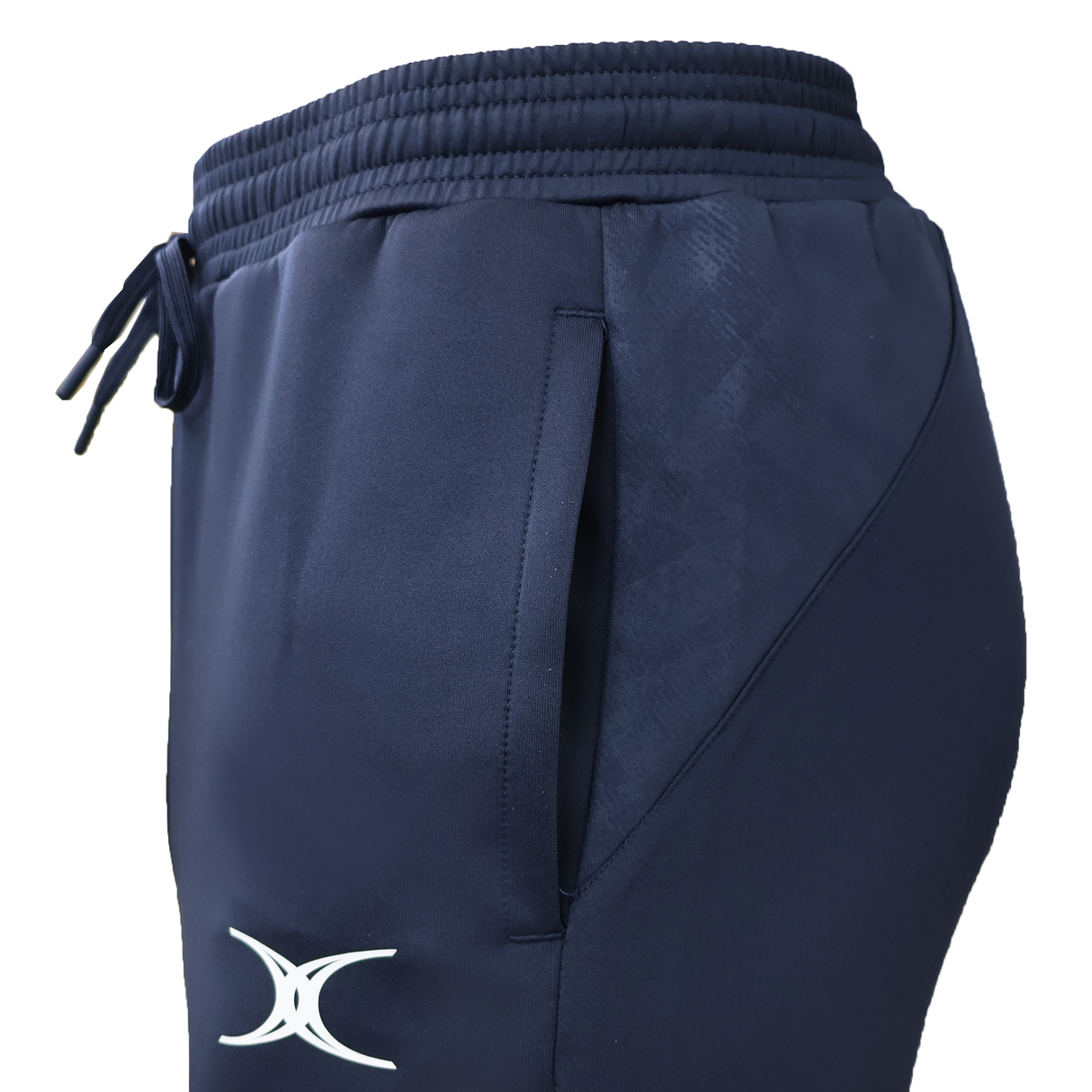 Close-up side view of the Gilbert GTS Training Pants in navy blue, featuring an elastic waistband, drawstring, side pocket, and a white Gilbert logo near the thigh—ideal for rugby training.