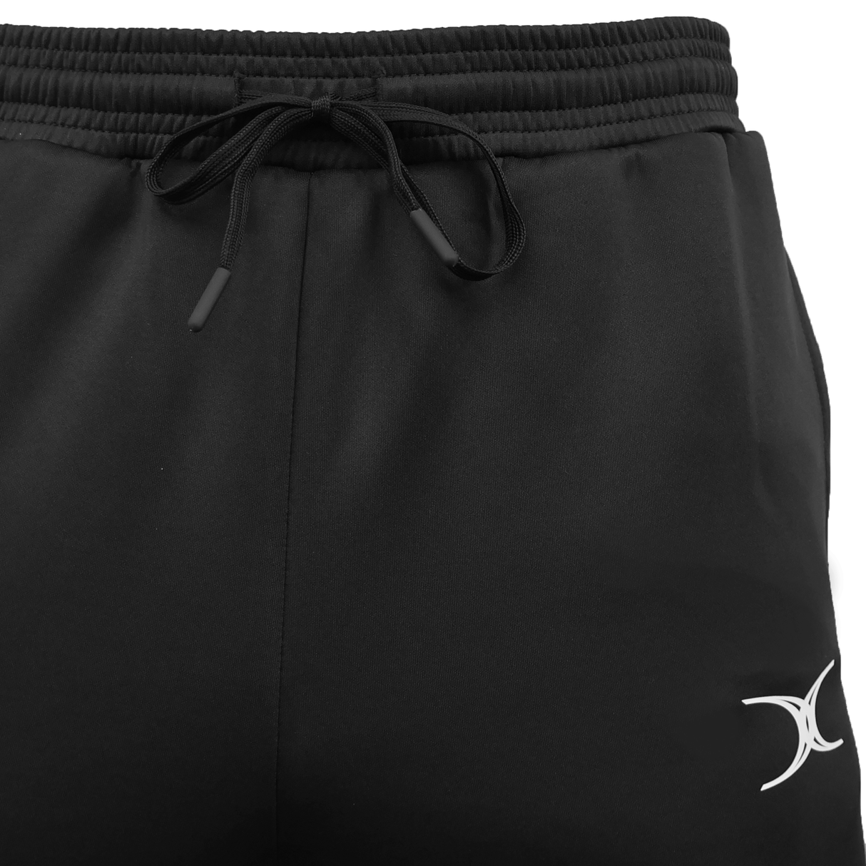 Close-up of Gilbert GTS Training Pants in black with a drawstring waistband and a white crescent logo on the left thigh—the perfect rugby training pants from Gilbert.