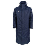The Gilbert TTS Touchline Jacket by Gilbert is a long, navy blue waterproof coaches jacket featuring a hood, front snap buttons, and a white embroidered logo on the left chest—making this classic parka perfect both on and off the field.