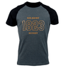 A dark gray and black raglan Gilbert Rugby 200 Year Anniversary Leisure Shirt by Gilbert features the text "Gilbert Rugby 1823" in bold gold letters on the front, celebrating its rich rugby history.