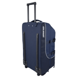 A Gilbert Club Tour Rugby Travel Bag in navy blue, featuring an extended handle, "GILBERT" printed on the side in white, two wheels, and protective side rails.