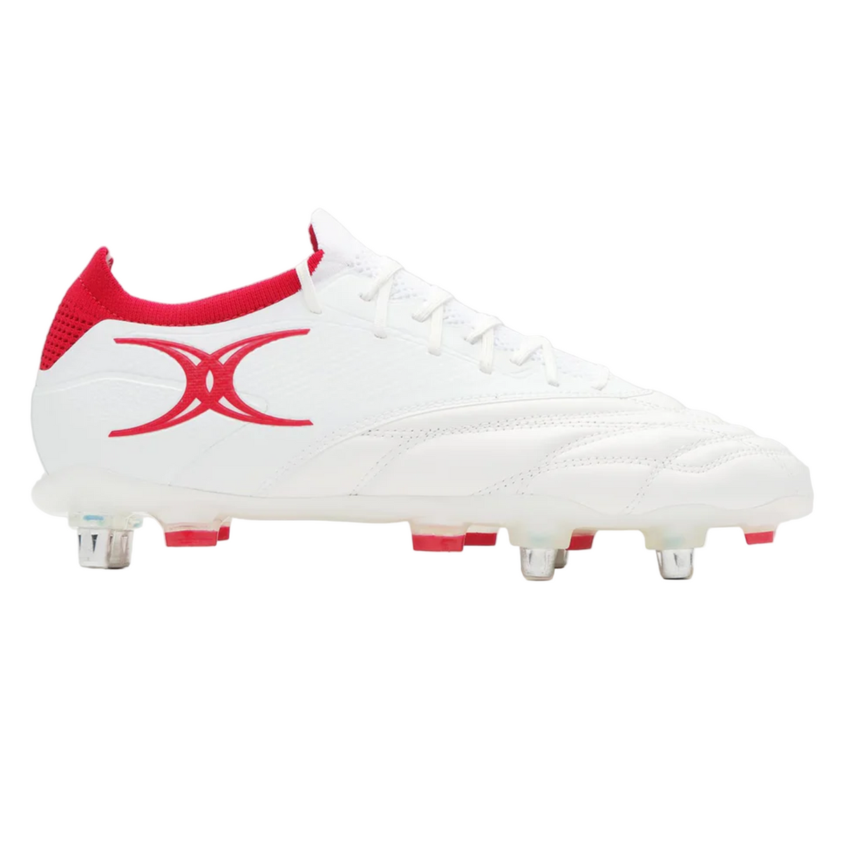The Gilbert Icon Players 6S - White is a white soccer cleat by Gilbert, designed for elite players, featuring red accents, a red side logo, and metal studs on the sole for superior grip on soft ground.