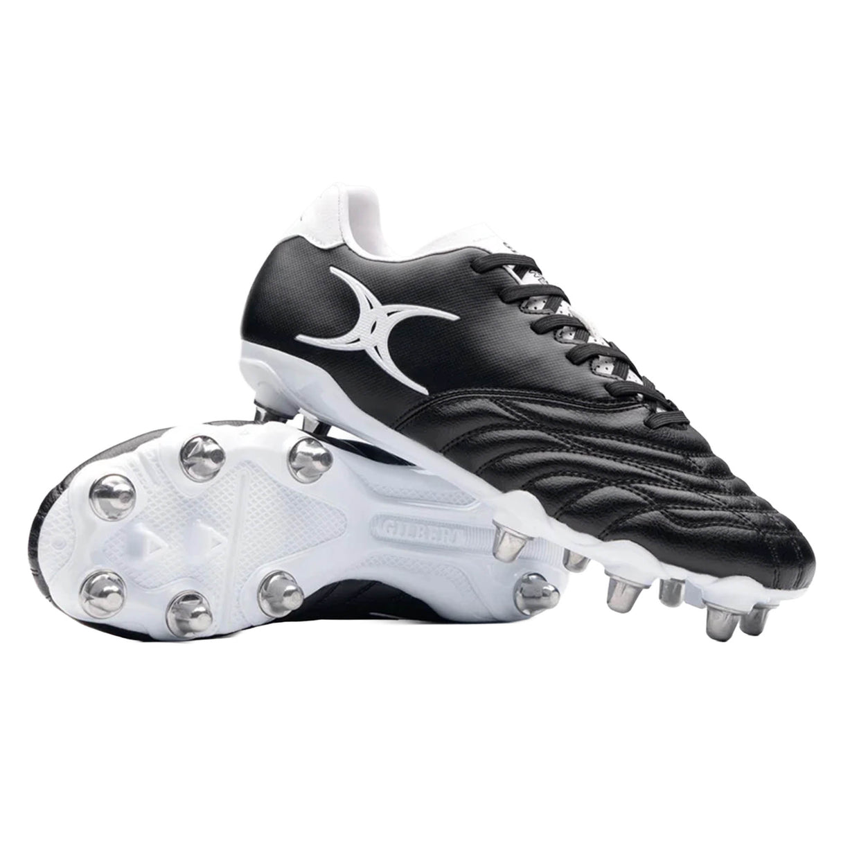 A pair of Gilbert Sidestep Icon 8S SG rugby boots in black and white, designed for soft ground with metal studs and a striking white abstract Gilbert logo on the side. One boot is shown upright, while the other lies on its side to display the sole.