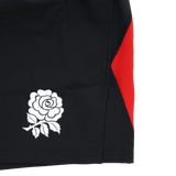 Close-up of the England Contact Training Short 24/25 by Umbro for Castore, featuring a black design with a white rose emblem and bold red side panel—ideal for intense contact training.