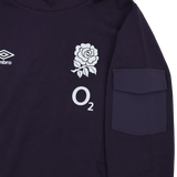 A close-up of the Women's England Presentation OH Hoodie 24/25 by Umbro, branded by Castore, showing a dark design with an Umbro logo, white rose emblem, "O2" text, and a right sleeve pocket.