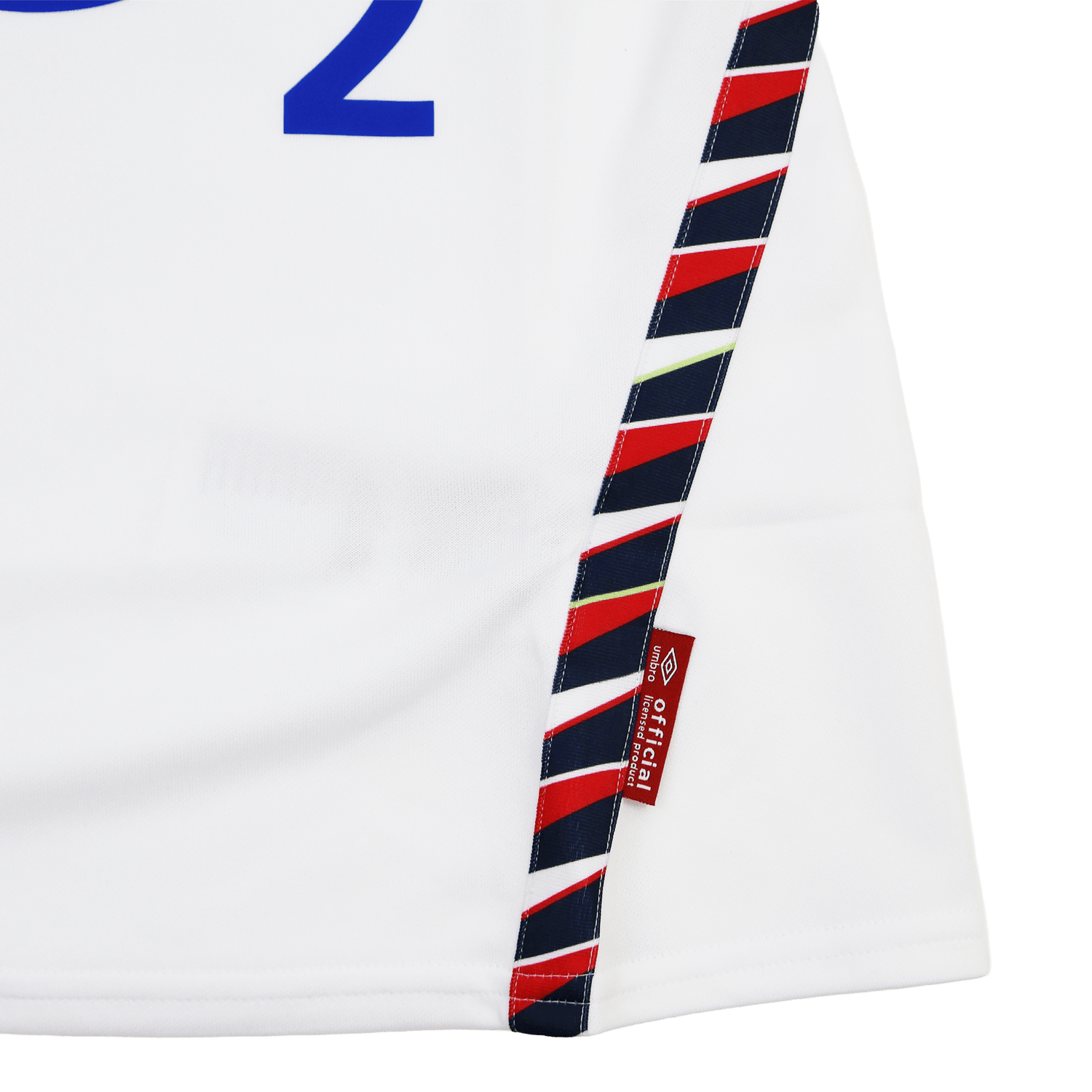 Close-up of the Women's Red Roses 24/25 Home Replica Jersey by Umbro, featuring white fabric, blue text, a diagonal red and navy striped trim, and a small red tag marked "official licensed product.