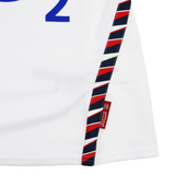 Close-up of the Women's Red Roses 24/25 Home Replica Jersey by Umbro, featuring white fabric, blue text, a diagonal red and navy striped trim, and a small red tag marked "official licensed product.