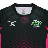 The Gilbert Sublimated Pro Jersey - Womens by Teamatical features a black and pink design with "World Rugby Shop" and a white abstract logo printed on the front.