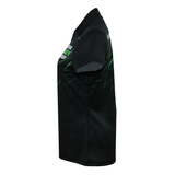 The Teamatical Gilbert Sublimated Pro Collared Jersey - Womens is a black short-sleeve polo featuring green graphic accents, displayed from the left side against a white background.