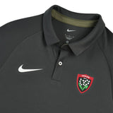 Dark gray short-sleeved RC Toulon Training Polo by Nike with a white swoosh on the chest and a red shield-shaped team crest featuring white lily-of-the-valley flowers.