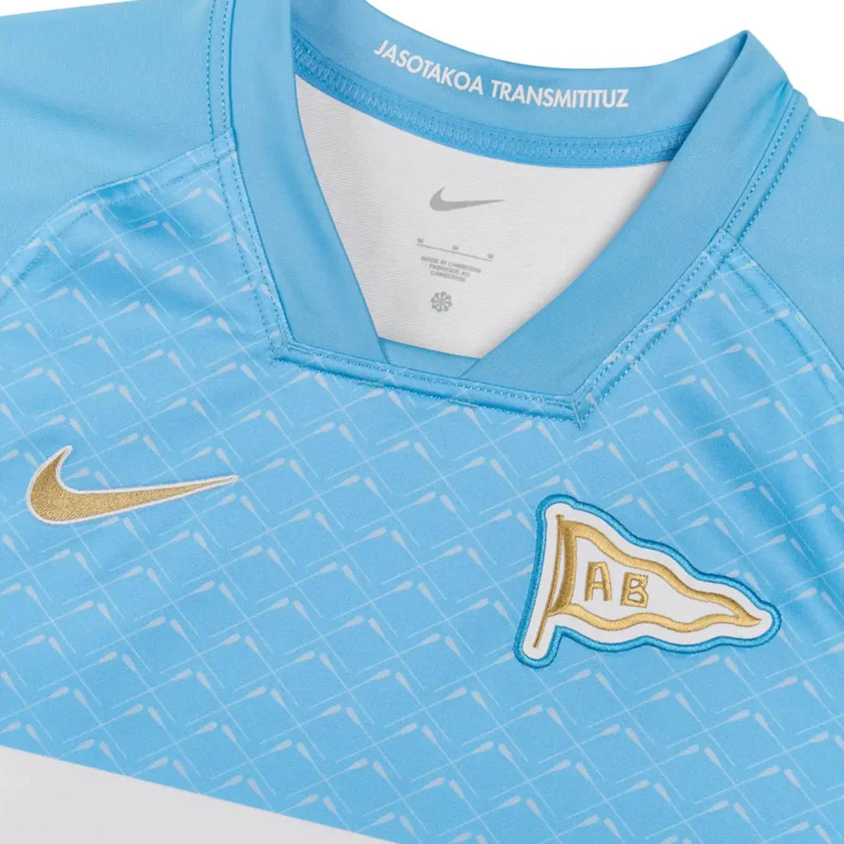 Light blue Aviron Bayonnais 26/27 Stadium Home Jersey by Nike with a geometric pattern, gold swoosh, “AB” flag emblem, and “JASOTAKOA TRANSMITITUZ” printed inside the collar.