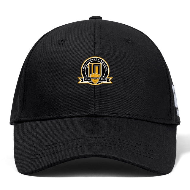 The Arrows Rugby Club 10th Anniversary Flexfit Drill Cap by EMB Canterbury features a gold, white, and black "10th Anniversary Season 2014-2023" embroidered logo on the front.