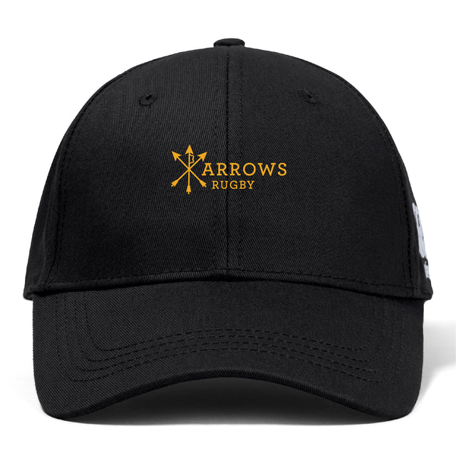 The Arrows Rugby Club Flexfit Drill Cap by EMB Canterbury is a black cap with "Arrows Rugby" and crossed arrows embroidered in yellow on the front, plus the CCC logo on the side.