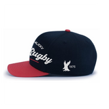 The EMB Augusta USA Rugby Elevated 1975 Eagles Snapback Cap features a navy blue and red design with "Rugby," Roman numerals "MMXXV," and a white eagle graphic with "1975" on the side.
